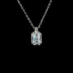 Silver necklace with a rectangular diamond pendant on a black background