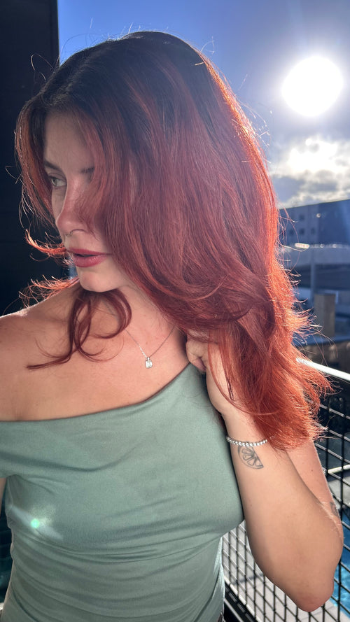 Stunning Red Haired Model on a rooftop wearing the Emerald Sugar Necklace and Thee Tennis Bracelet by Lea Fine Jewelry