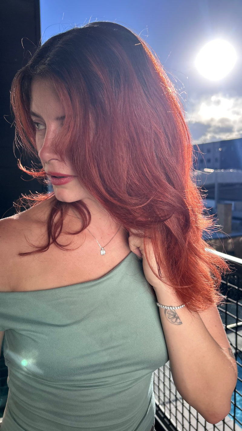 Stunning Red Haired Model on a rooftop wearing the Emerald Sugar Necklace and Thee Tennis Bracelet by Lea Fine Jewelry