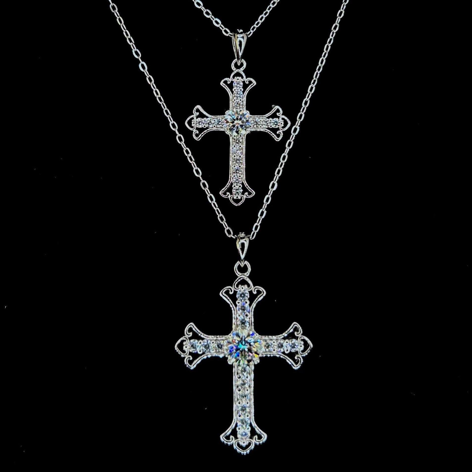 Two silver cross necklaces on a black background